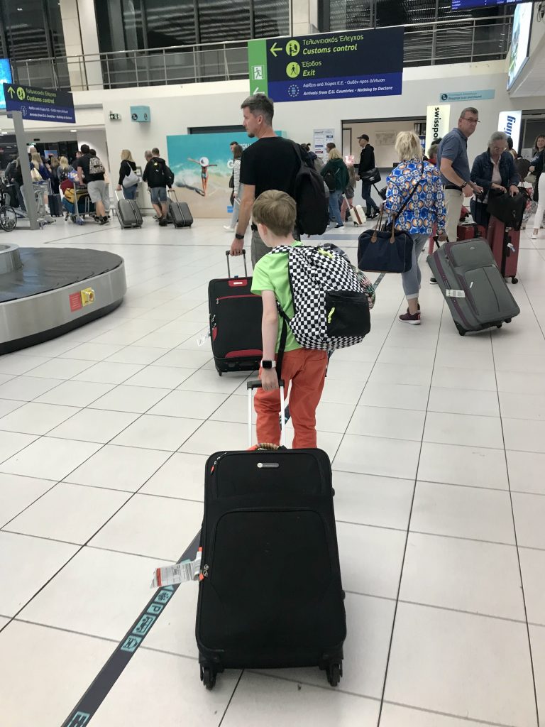 People walking thoguh airport with suitcases