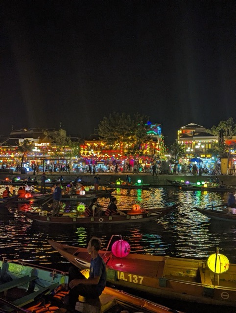 Image of brightly lit boats on a river at night in Vietnam